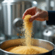 Brasseur saupoudrant de la levure dans un grand tank de fermentation
