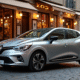 Renault Clio Phase 2 argentée sur une rue pavée en bistro européen